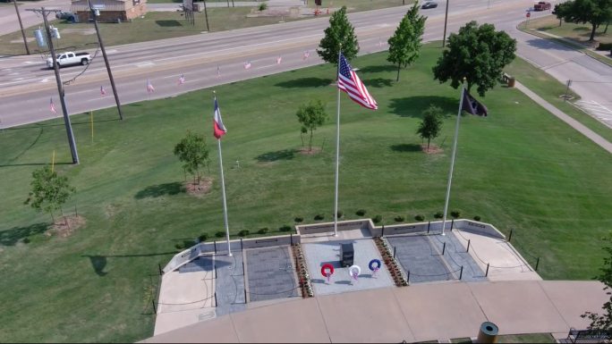 美国国旗和另外两面国旗在绿色的场地上挥动的高角度照片