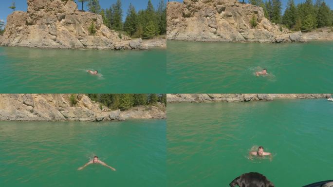 人从岩石上跳水，游过湖泊