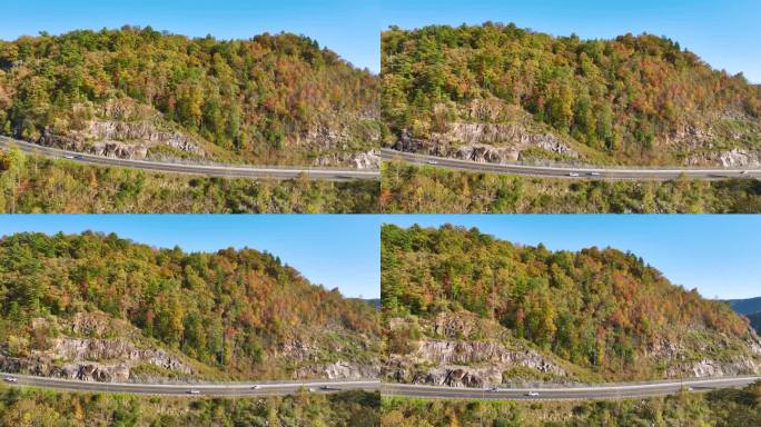 北卡罗莱纳州宽阔的高速公路通往阿巴拉契亚山脉，那里有黄色的秋天森林和快速移动的交通。美国国家公园内的
