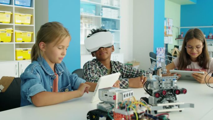 孩子们带着平板电脑和AR耳机在机器人俱乐部闲逛