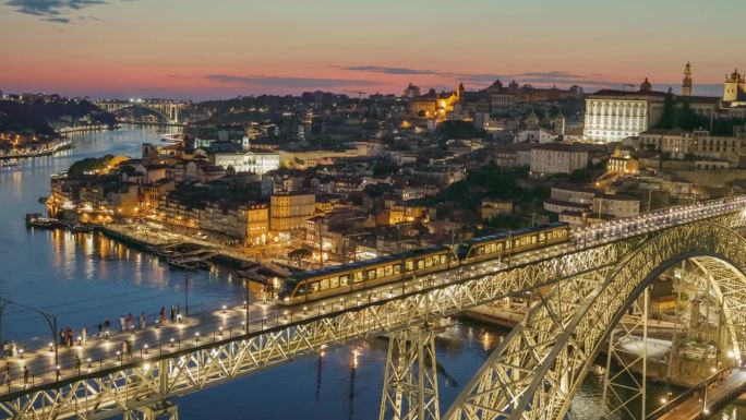 葡萄牙波尔图的日落晚景。平移拍摄波尔图老城和路易一世桥与城市灯光