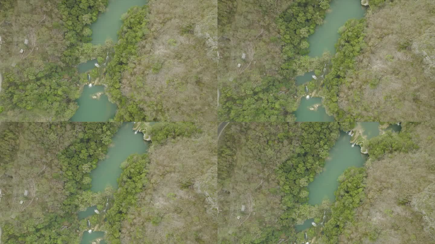 空中无人机拍摄流经森林的河流