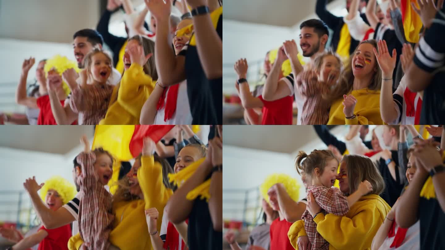 兴奋的足球迷，母亲带着小女儿，在体育场支持德国国家队的实况足球比赛。