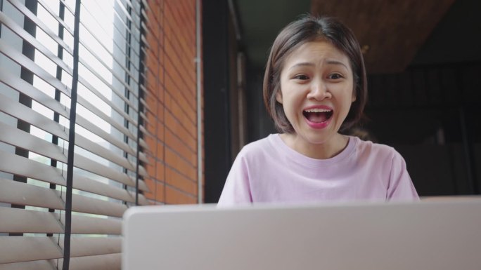 年轻的亚洲女学生在远程在线课堂上使用笔记本电脑进行视频会议，使用笔记本电脑学习