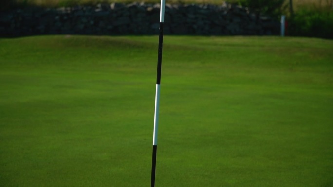 高尔夫球旗在推杆洞中的特写镜头。