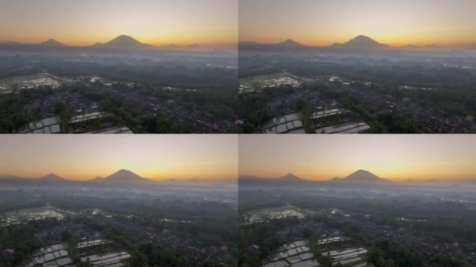 空中无人机拍摄的印尼巴厘岛丛林中，以阿贡火山为背景的高山梯田的日出景象。