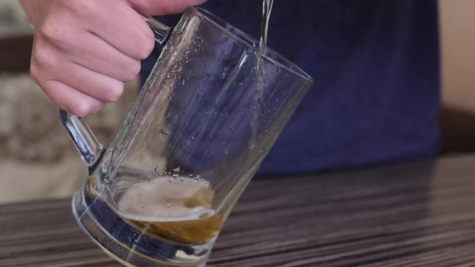 将未过滤的啤酒泡沫填充到大啤酒杯边缘的过程