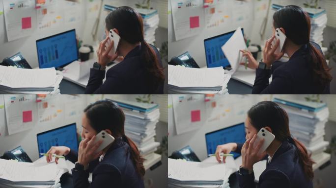 年轻的女企业家一边打电话一边在办公室里看文件。