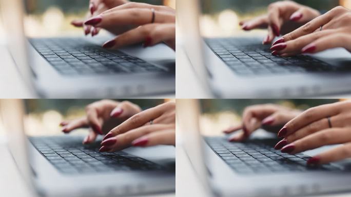 女人的手在键盘上打字，特写侧视图。在笔记本电脑键盘上打字。精心修饰的女人的手。在电脑上工作的女商人