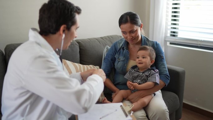 儿科医生在家里用听诊器检查男婴