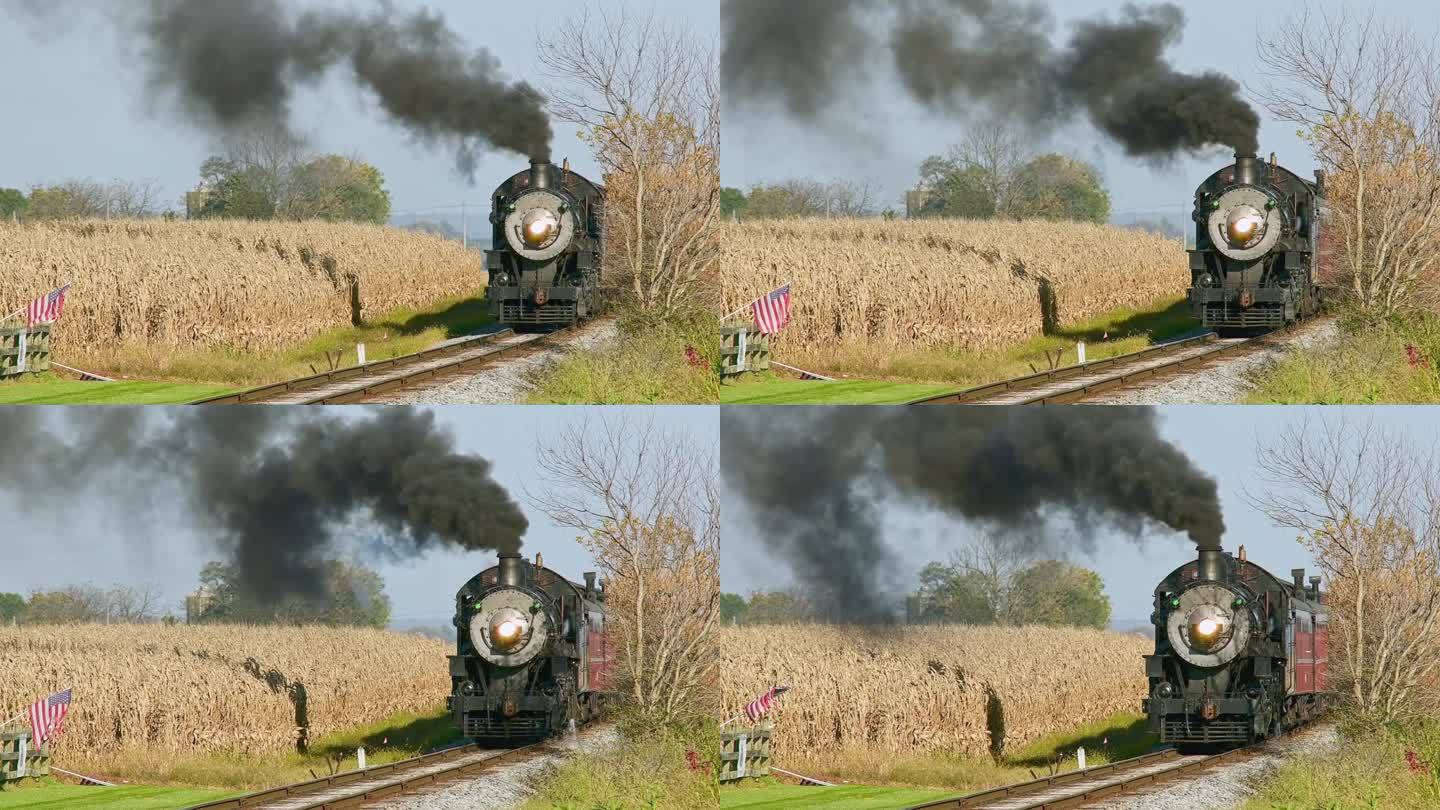 一辆驶近的古董蒸汽客运火车，吹着黑烟，经过玉米地