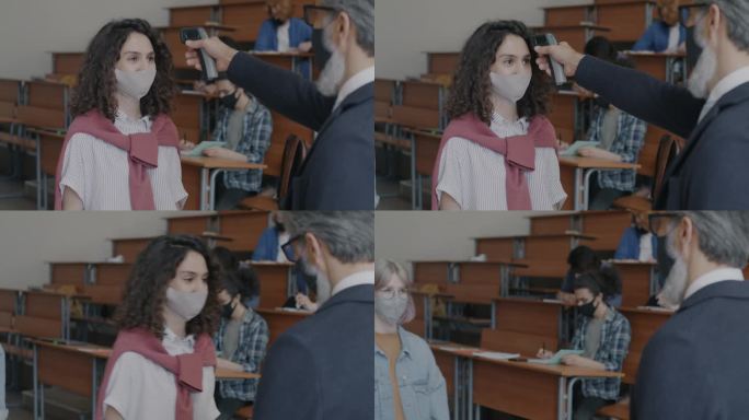 大流行期间，教师在大学教室里用红外体温计为戴口罩的学生测量体温