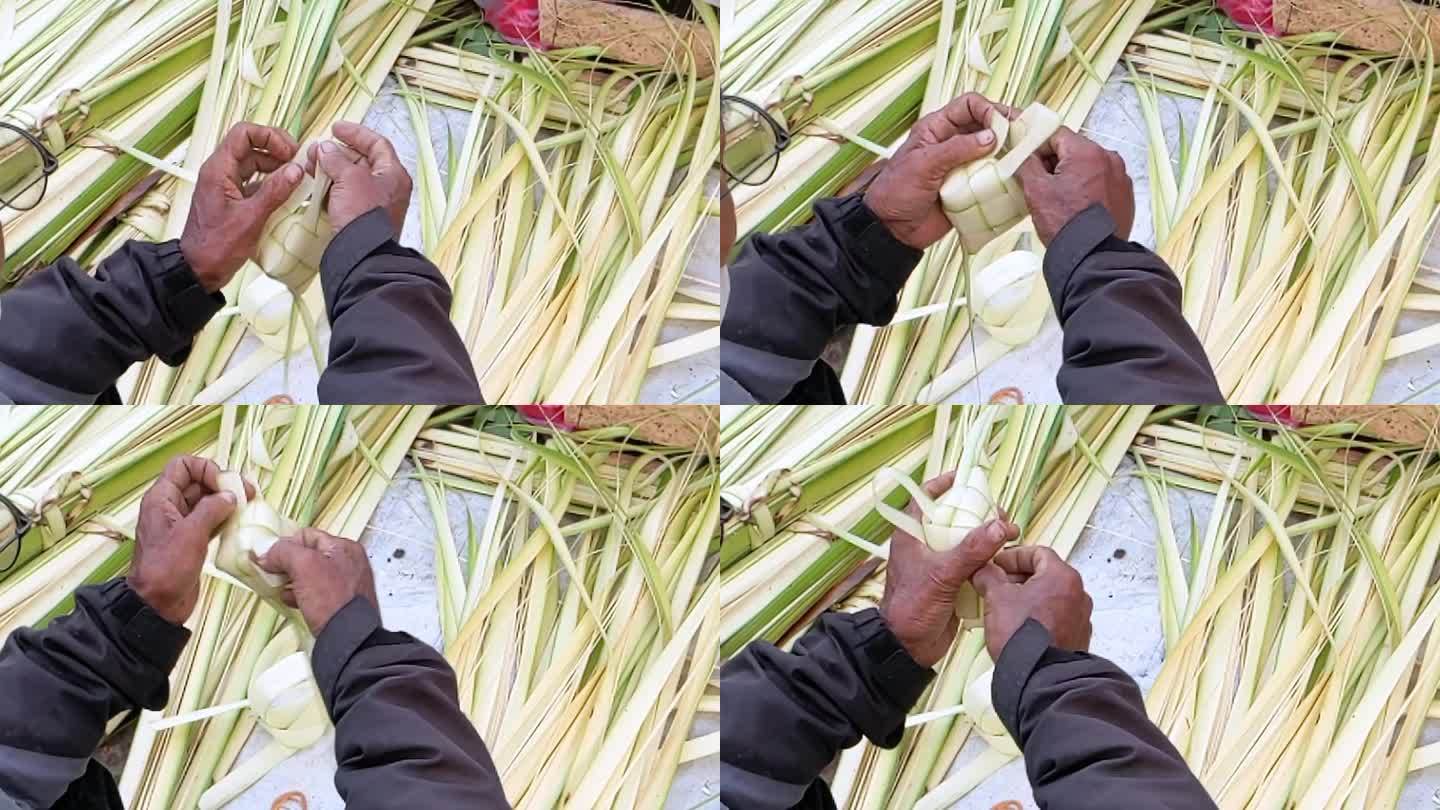 缓慢的运动。亚洲人用手把椰子叶包成Ketupat。