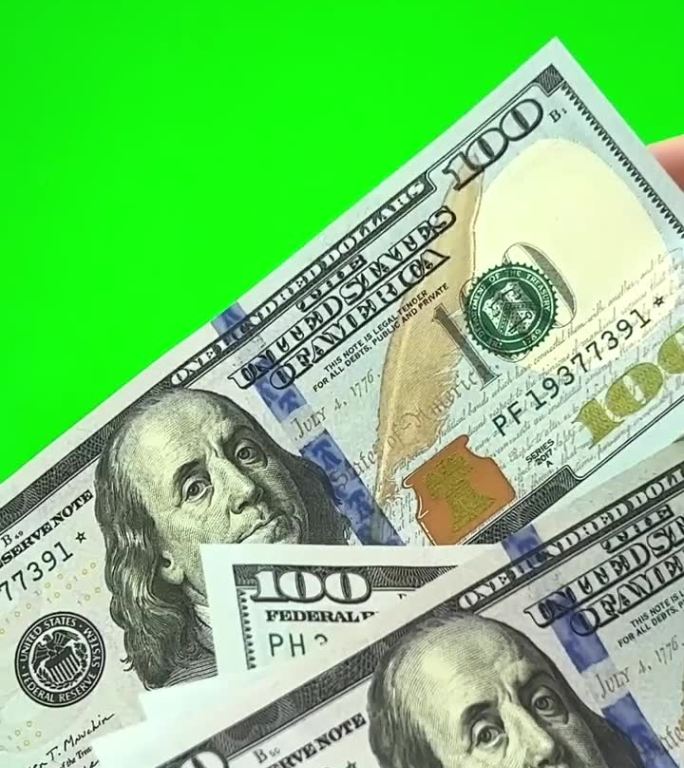 在绿色背景上，铬色男性的手给女性的手一百美元的钞票，女性计数每一张钞票考虑其真实性，表示大拇指快乐交