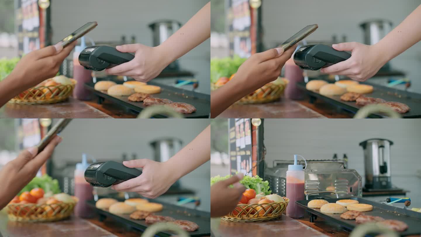一位顾客在餐车上买了一个美味的汉堡，用智能手机付款。非接触式支付。申请网上银行付款。非接触式技术。A