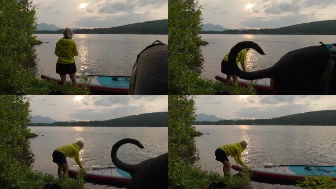 女子划桨板(SUP)穿过宁静的山间湖泊