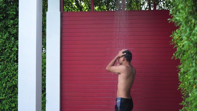 运动健将在旅馆的游泳池里洗个淋浴以清洁卫生。