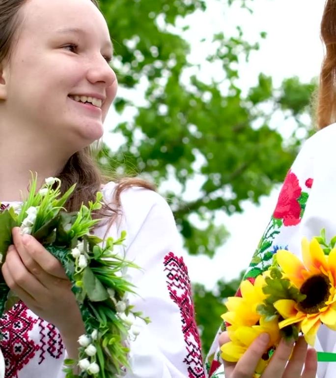两个漂亮的年轻女孩穿着刺绣衬衫向日葵田花红色明亮阳光的头发背景的文字伊万库帕拉庆祝乌克兰人民的节日