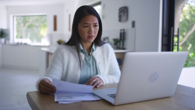 沮丧的亚洲女人，笔记本电脑和文件在金融危机，收据或开支在压力，焦虑或账单在家里。有财务方面的文书工作