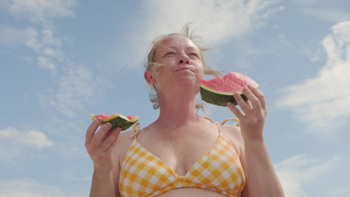 女人吃西瓜。海边野餐
