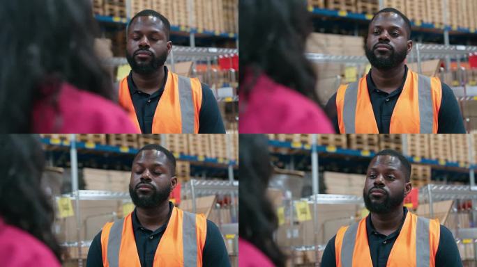 一个非洲人在仓库听经理的讨论