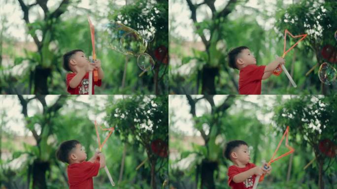 快乐的亚洲男孩吹彩色肥皂泡在一个阳光明媚的日子:无忧无虑的童年乐趣