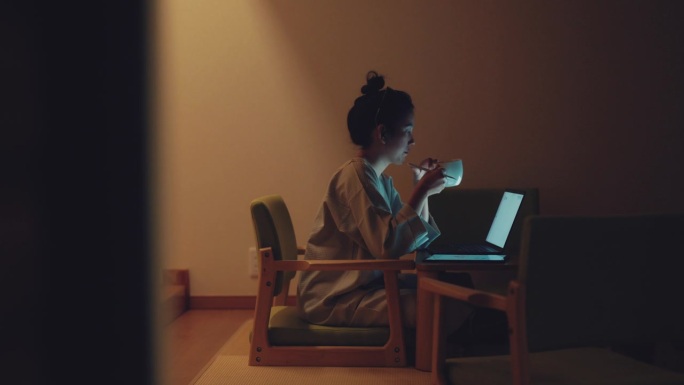 亚洲女商人深夜在家里的客厅用笔记本电脑工作。