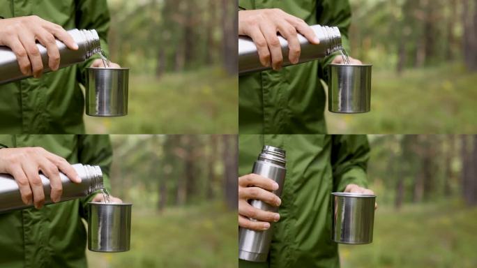 一个人在森林里把热水瓶里的热茶倒进杯子里。自然探险、旅游露营的理念