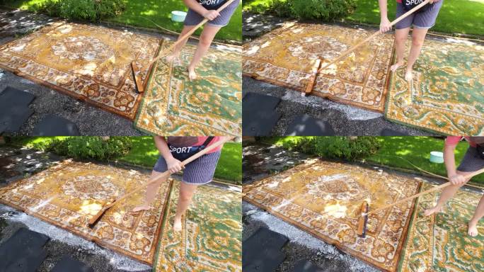 在院子里用带清洁剂的刷子洗地毯