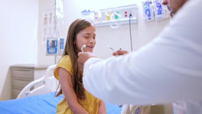 医生把听诊器放在一个9岁女孩的头上听她的心跳