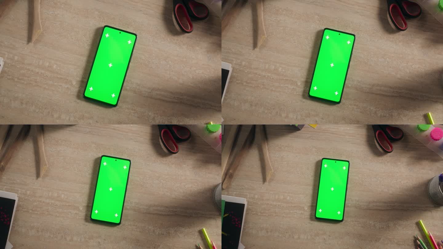 智能手机模拟绿屏Chromakey显示与运动跟踪器。高架放大旋转镜头视图的手机设备上的创意书桌与彩色