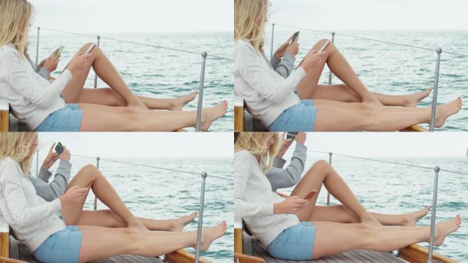 女孩朋友拍照智能手机边缘在海洋上豪华的生活方式帆船快乐的冒险旅行度假社交媒体分享
