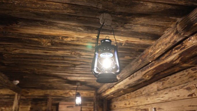 一盏煤油灯在木屋里燃烧
