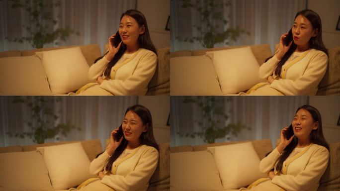 韩国年轻女子晚上和朋友在智能手机上聊天，和伴侣一起听笑话和趣事，在舒适的沙发上休息，在一个时尚的房间