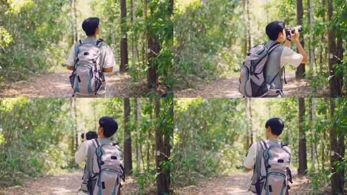 亚洲年轻英俊的男性背包客独自在森林野外旅行。在假期旅行中，有魅力的男人在大自然的树林里四处张望和探索