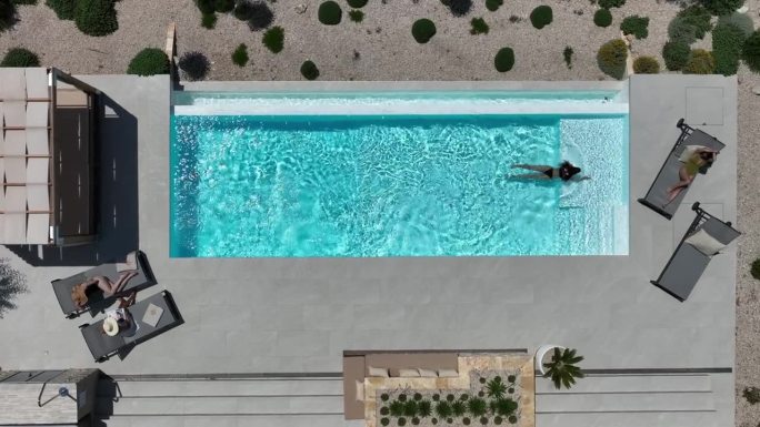 女子在海边私人别墅的游泳池里游泳