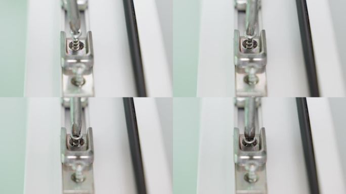 一个卷曲的螺丝起子用自攻螺丝拧着塑料门的金属插销(特写)