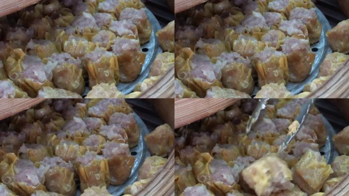 在竹条圈盒中，用蒸好的水将蒜末撒在六个猪肉馅上。