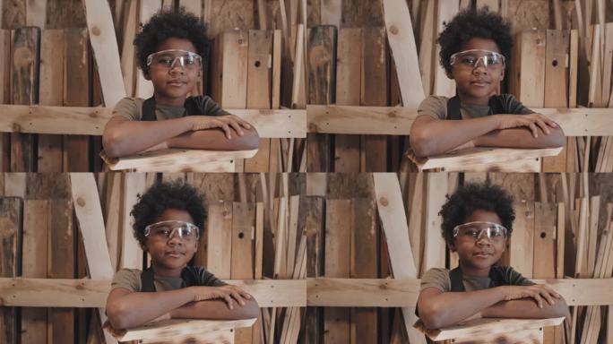 愉快的非洲裔美国男孩戴着眼镜站在木板背景