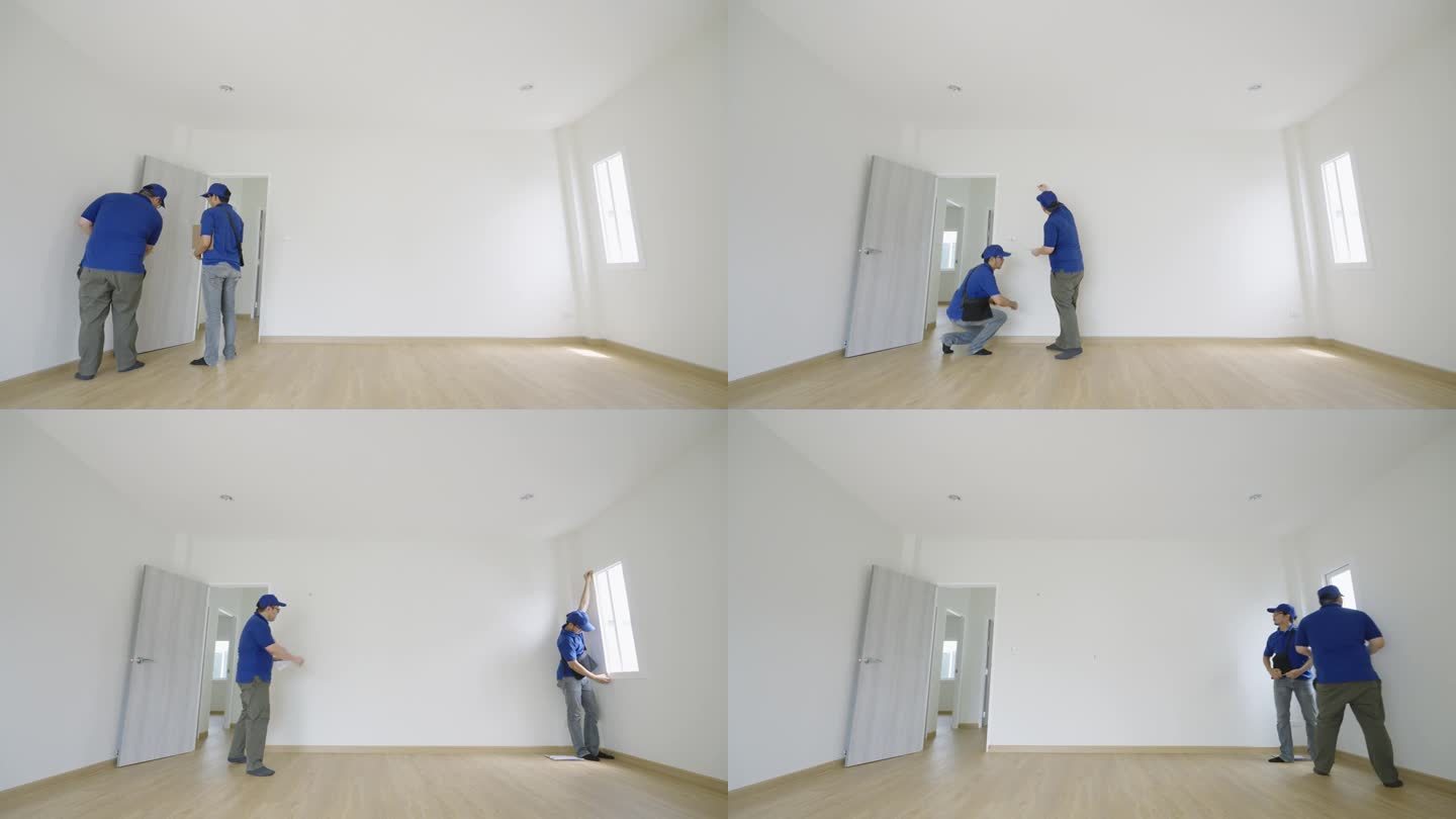 两个穿蓝衬衫的亚洲电工正在检查一间新空房间的尺寸