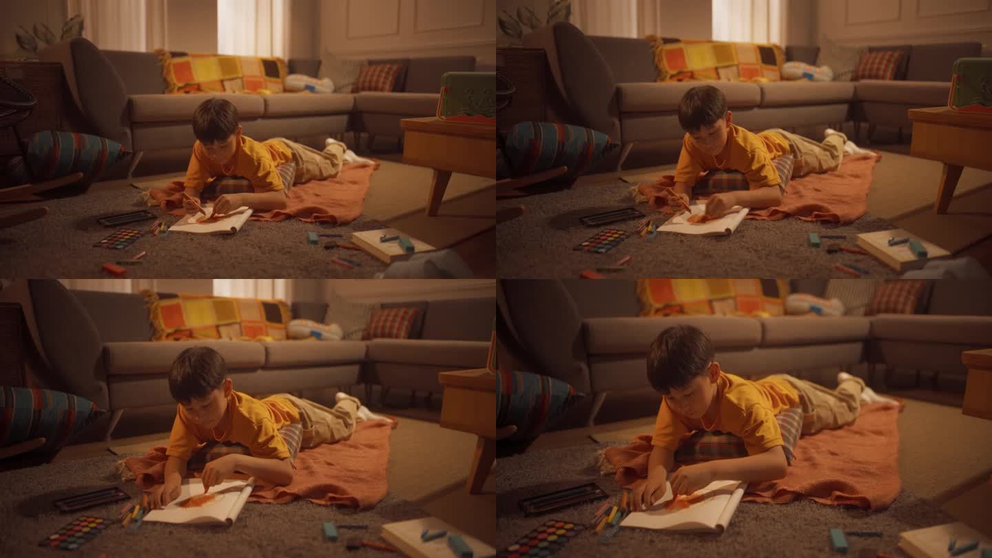 年轻的韩国男孩躺在地板上，用钢笔、铅笔、水彩画在笔记本上，在温暖的光线下舒适的公寓里。未来的艺术家是