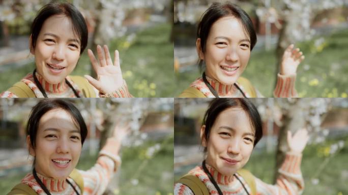 周末，一名亚洲女子站在日本一片以樱花为背景的田野里，拍下了自拍照视频。