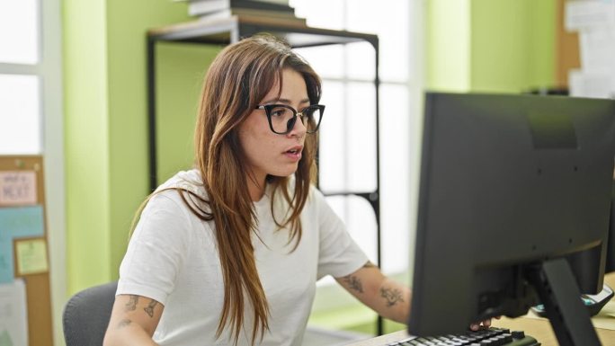 年轻漂亮的西班牙裔女商务工作者强调在办公室使用电脑时摘掉眼镜