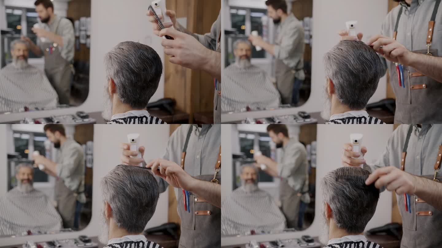 理发店里理发师的手在男人头上喷水和梳头的特写