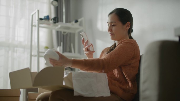 亚洲女子拍照手机发社交媒体拆包拆箱