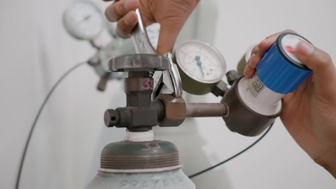 在专门实验室里给钢瓶安装氮气压力表阀门的科学家