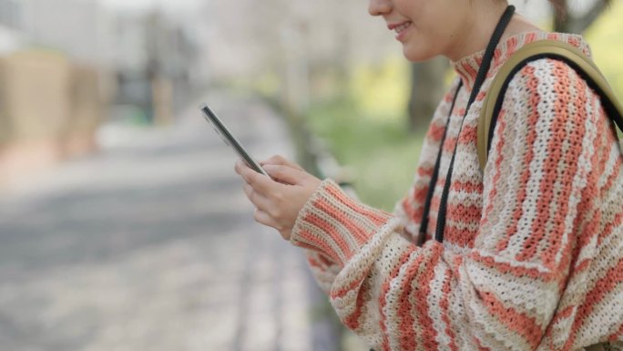 一名住在日本的亚洲女子用智能手机给男友发短信。
