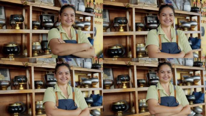 微笑的亚洲女厨师站着，手臂交叉，背景是她的小生意。