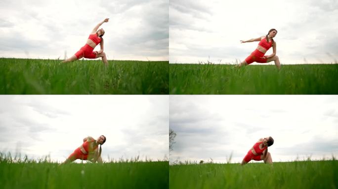 穿着橙色服装的运动女子在绿色清新的田野里练习瑜伽，极简主义的场景。用腿和胳膊做伸展体式。健康生活方式