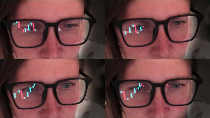 Сlose一名戴眼镜的女子注视着不断变化的数字、股票和金融图表